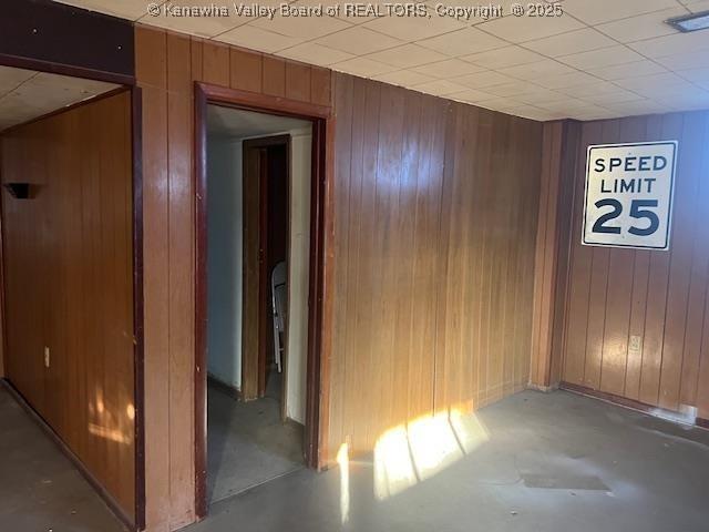 interior space featuring wooden walls and concrete flooring