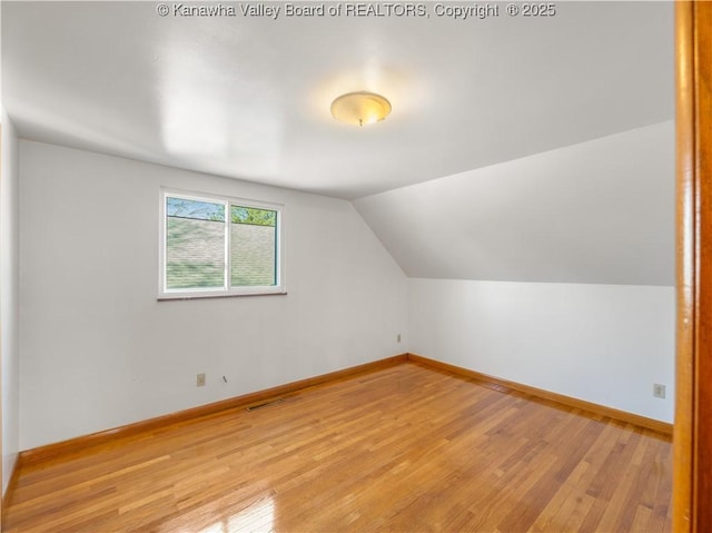 bonus room with lofted ceiling and light hardwood / wood-style flooring