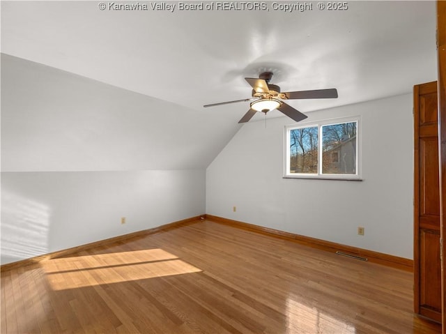 additional living space with ceiling fan, vaulted ceiling, and light wood-type flooring