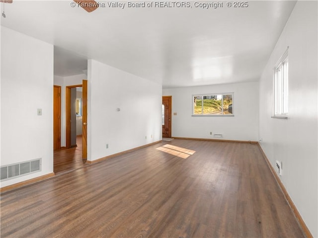 unfurnished living room with dark wood-type flooring