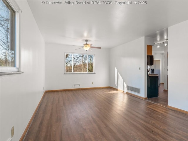 spare room featuring dark hardwood / wood-style flooring, track lighting, and ceiling fan