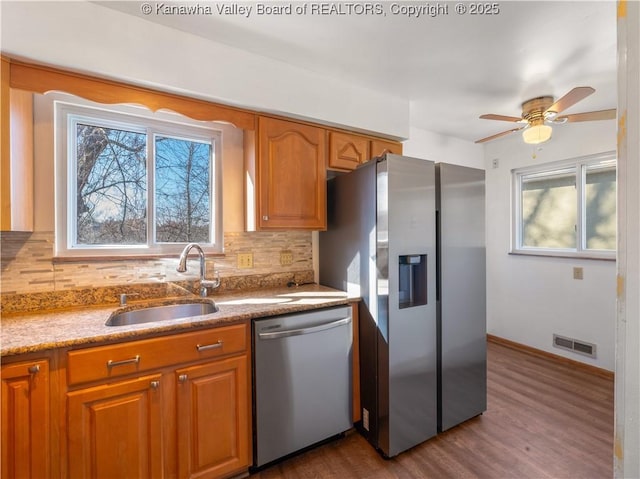 kitchen featuring stainless steel appliances, tasteful backsplash, plenty of natural light, and sink