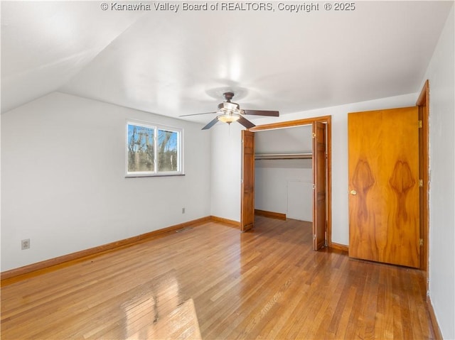 unfurnished bedroom with lofted ceiling, light hardwood / wood-style flooring, a closet, and ceiling fan