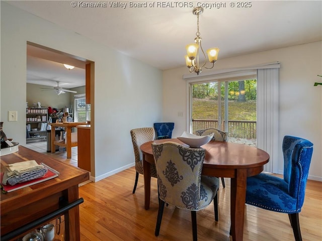 dining space featuring ceiling fan with notable chandelier and light hardwood / wood-style flooring