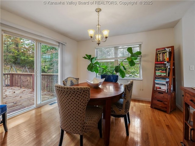 dining area with a chandelier and light hardwood / wood-style flooring