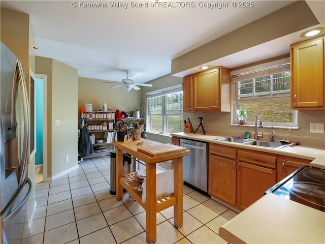 kitchen with sink, light tile patterned floors, ceiling fan, and appliances with stainless steel finishes