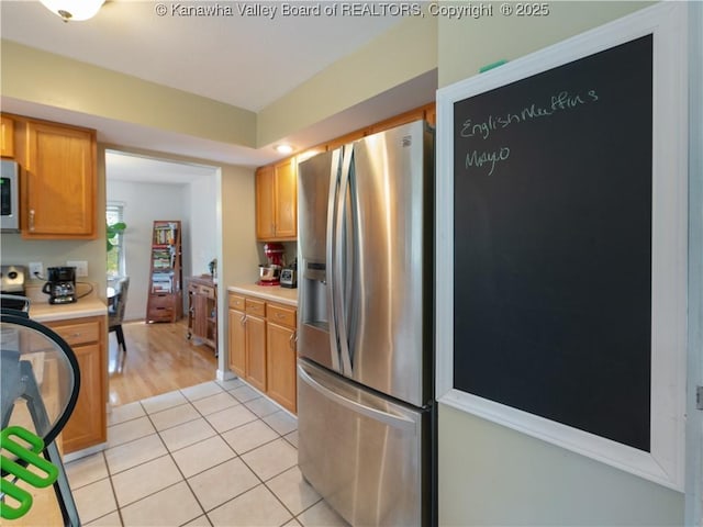 kitchen featuring light tile patterned floors and stainless steel fridge with ice dispenser