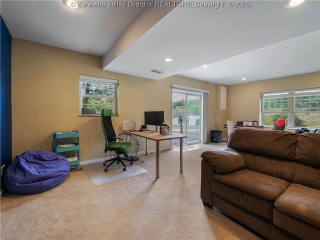 office space with plenty of natural light and light carpet