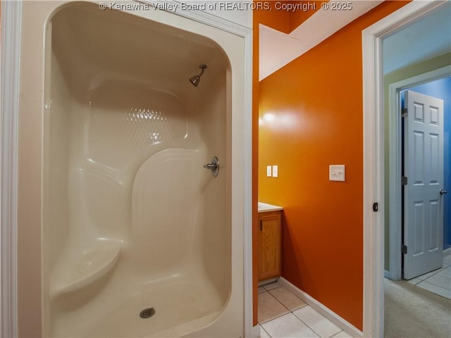 bathroom featuring vanity, a shower, and tile patterned floors