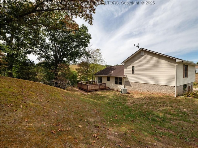 back of house with a wooden deck, central AC unit, and a lawn