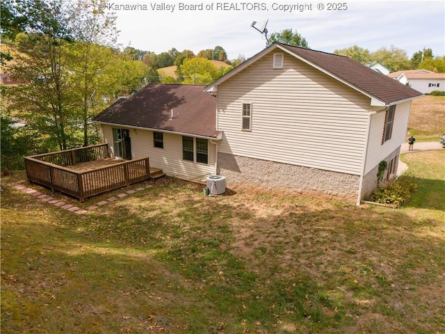 rear view of house with a wooden deck, a yard, and central AC