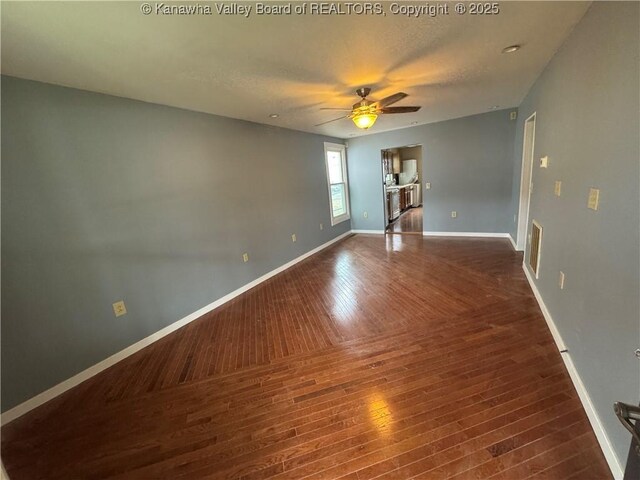 spare room with ceiling fan, a textured ceiling, and dark hardwood / wood-style flooring