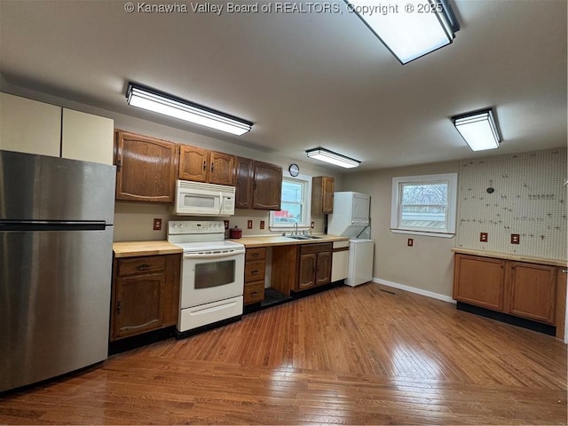 kitchen featuring sink, white appliances, and light wood-type flooring