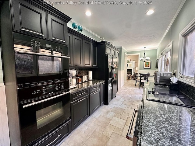 kitchen featuring hanging light fixtures, ornamental molding, a notable chandelier, and black appliances