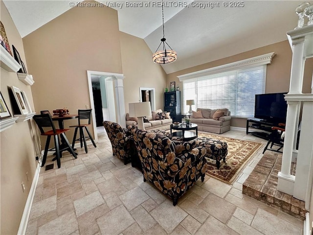 living room with ornate columns and high vaulted ceiling