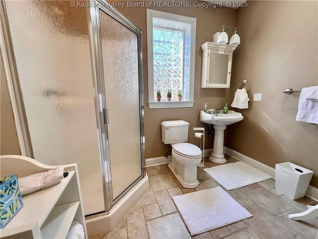 bathroom featuring toilet, an enclosed shower, and sink