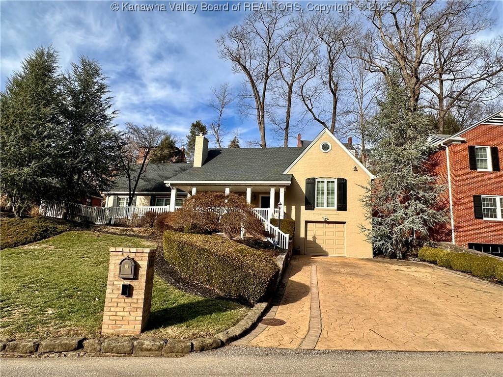 view of front facade featuring a garage, a front lawn, and a porch