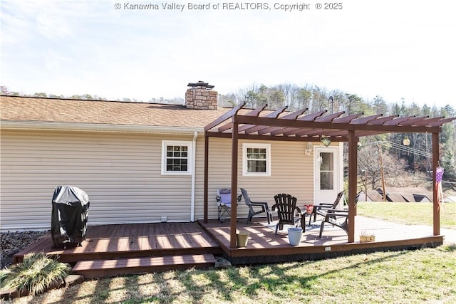 back of property featuring a wooden deck, a lawn, and a pergola