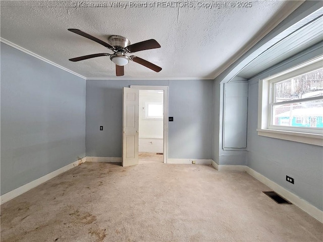 unfurnished room with ornamental molding, light carpet, ceiling fan, and a textured ceiling