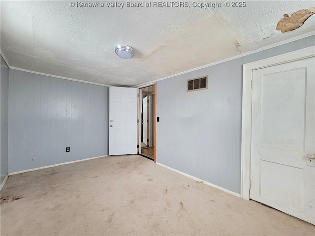 carpeted spare room with ornamental molding and a textured ceiling