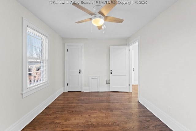 spare room with dark hardwood / wood-style floors and ceiling fan