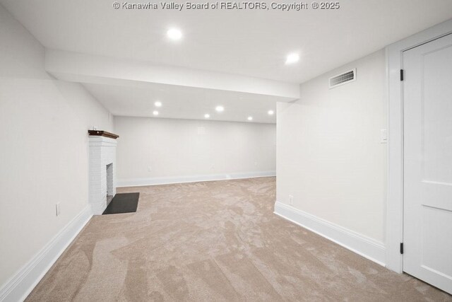 basement featuring a fireplace and light colored carpet