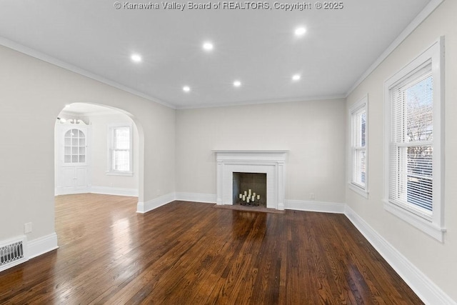 unfurnished living room with wood-type flooring and ornamental molding