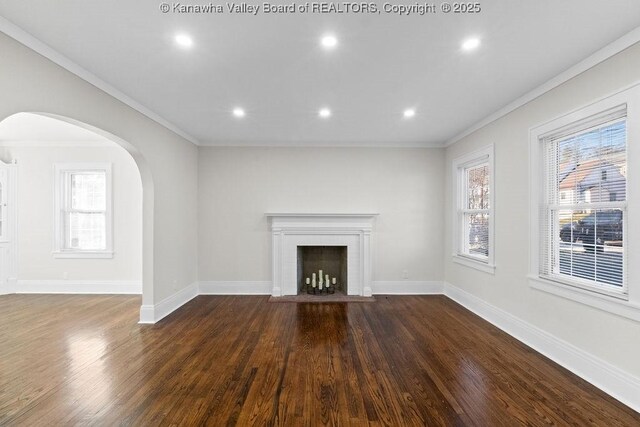 unfurnished living room featuring crown molding and dark wood-type flooring