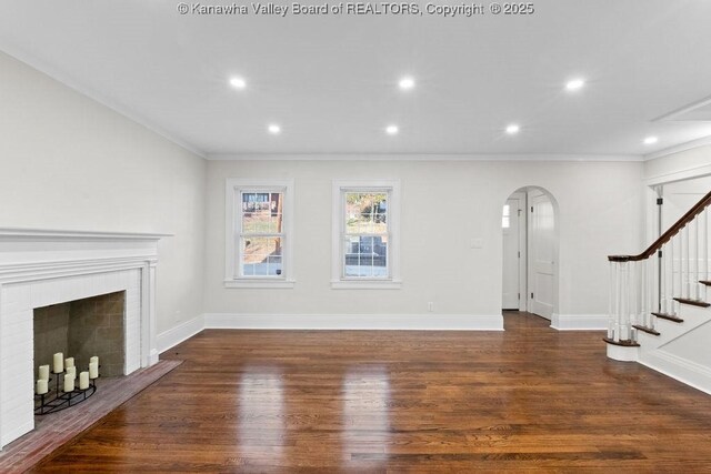 unfurnished living room featuring crown molding, a fireplace, and dark hardwood / wood-style flooring