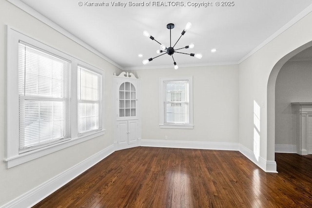 spare room featuring ornamental molding, a chandelier, and dark hardwood / wood-style flooring