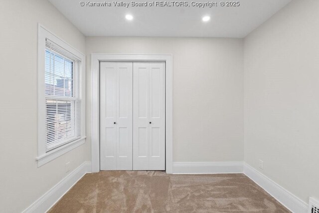 unfurnished bedroom with carpet flooring and a closet