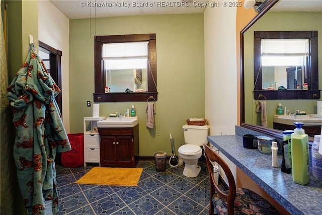 bathroom featuring vanity, plenty of natural light, and toilet