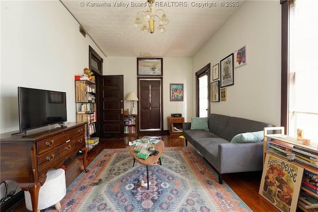 living room with dark wood-type flooring and a chandelier