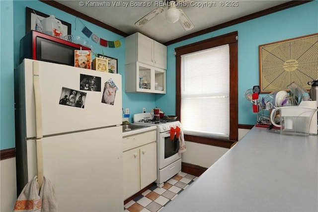 kitchen featuring crown molding, ceiling fan, white cabinets, and white appliances