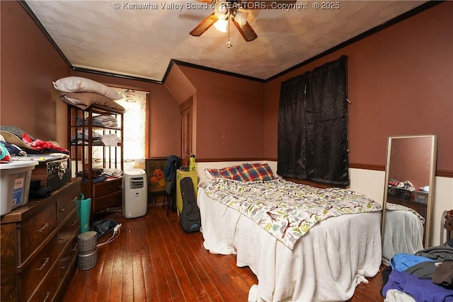 bedroom with dark wood-type flooring, ornamental molding, and ceiling fan