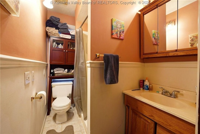 bathroom featuring walk in shower, tile patterned floors, vanity, and toilet