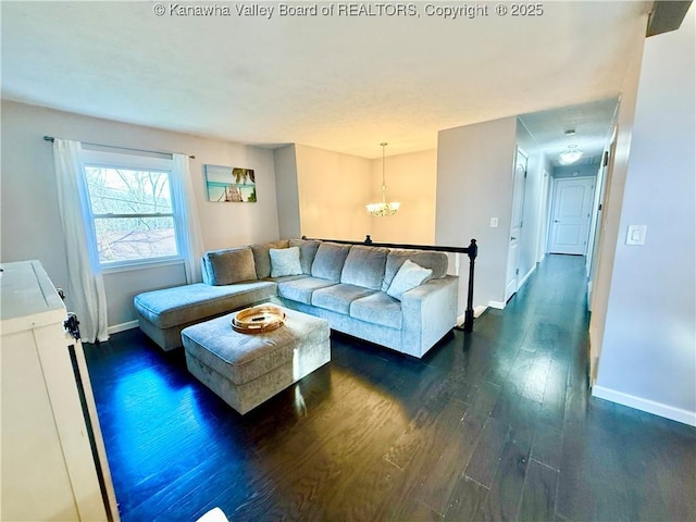 living room featuring dark hardwood / wood-style flooring and an inviting chandelier