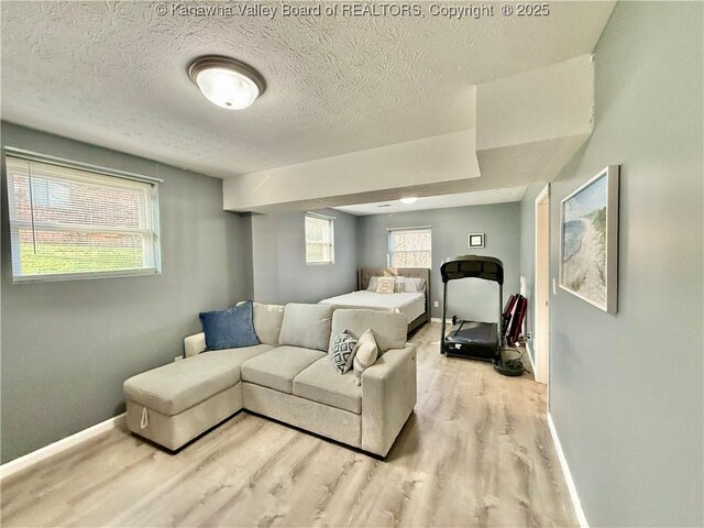 bedroom with light hardwood / wood-style flooring and a textured ceiling