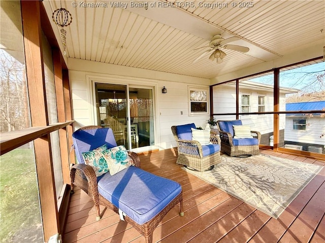 sunroom with ceiling fan and wooden ceiling