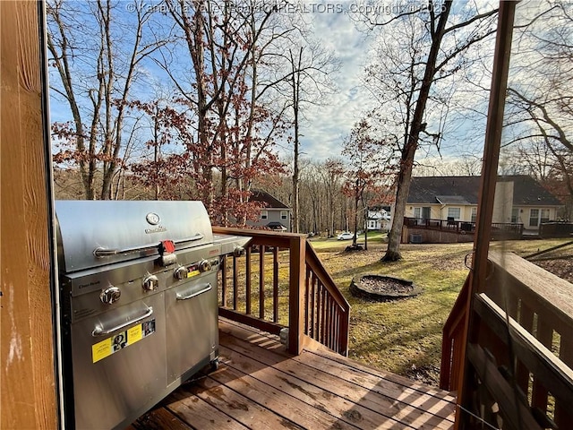 wooden terrace with a grill and a yard