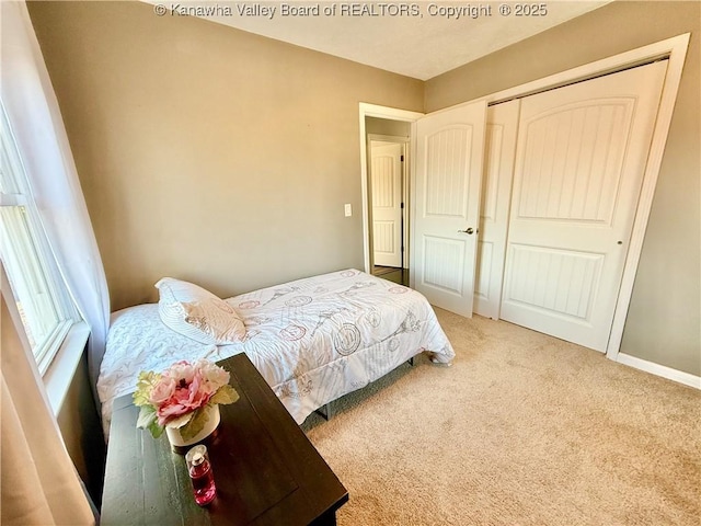 bedroom with light colored carpet and a closet