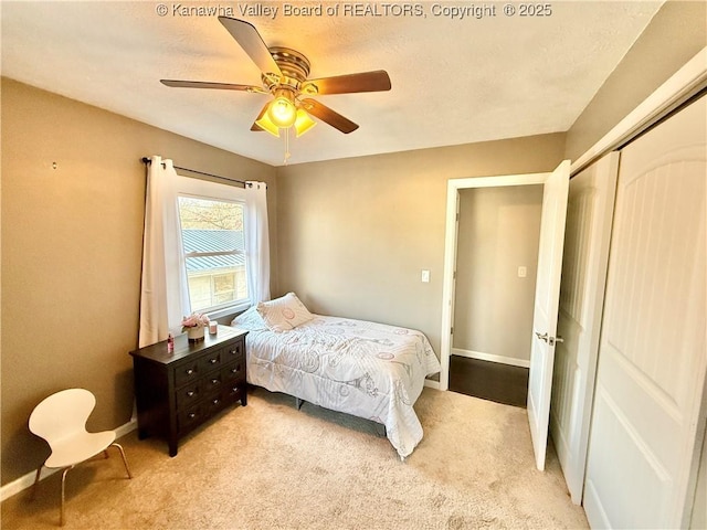 bedroom with light carpet, ceiling fan, and a closet