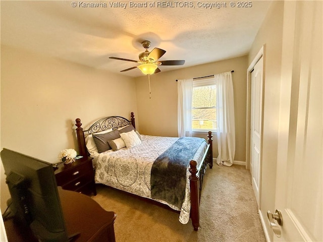 carpeted bedroom featuring ceiling fan, a closet, and a textured ceiling