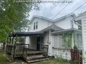 rear view of property featuring a wooden deck