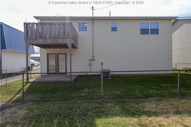 back of property featuring cooling unit, a balcony, and a yard