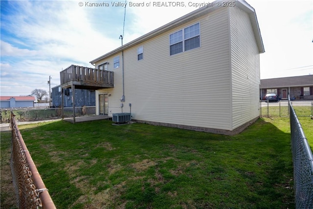 rear view of house featuring central AC unit, a lawn, and a deck