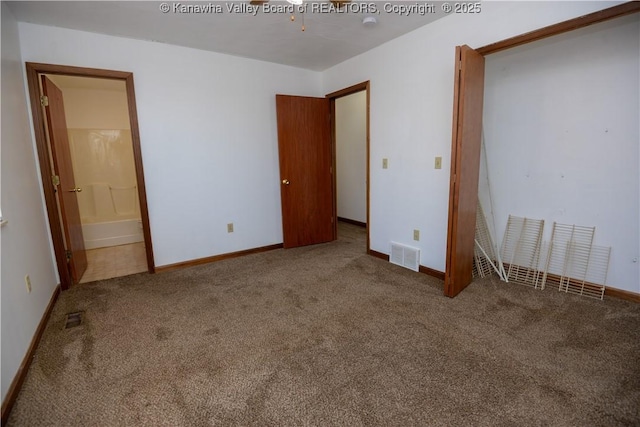 unfurnished bedroom featuring carpet floors and connected bathroom