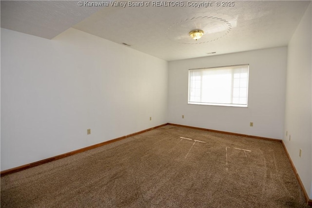 unfurnished room with carpet flooring and a textured ceiling