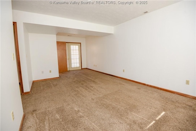 spare room featuring carpet floors and a textured ceiling