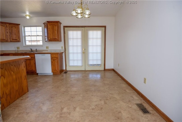 kitchen featuring french doors, sink, decorative light fixtures, a chandelier, and white dishwasher